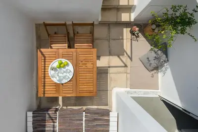 a balcony with a table and a bowl of grapes at Vamare Beachfront House in Gennadi