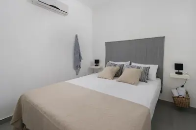 a white bedroom with a large white bed with pillows at Vamare Beachfront House in Gennadi