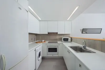 a kitchen with white cabinets and a sink at Vamare Beachfront House in Gennadi
