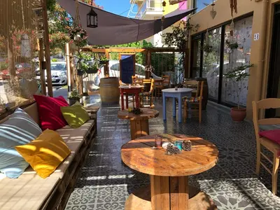 a patio with couches and tables on a street at Rhodes Backpackers Boutique Hostel and Apartments in Rhodes Town