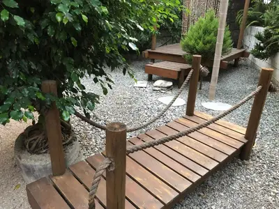 a wooden bridge with a rope and a bench at Rhodes Backpackers Boutique Hostel and Apartments in Rhodes Town
