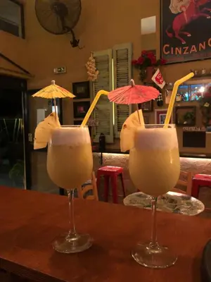 two glasses with umbrellas on top of a table at Rhodes Backpackers Boutique Hostel and Apartments in Rhodes Town