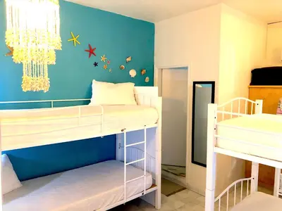 a bedroom with two bunk beds and a blue wall at Rhodes Backpackers Boutique Hostel and Apartments in Rhodes Town
