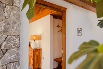 a room with a lamp on a table next to a stone wall at Caesars Gardens Hotel & Spa - Adults Only in Líndos