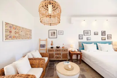 a living room with a white couch and a chandelier at Caesars Gardens Hotel & Spa - Adults Only in Líndos