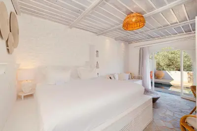 a white bedroom with a white bed and a ceiling at Caesars Gardens Hotel & Spa - Adults Only in Líndos