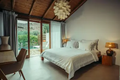 a bedroom with a bed and a chandelier at Caesars Gardens Hotel & Spa - Adults Only in Líndos