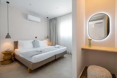 a bedroom with a large bed and a mirror at Bella Vista Stegna in Archangelos