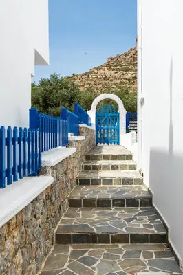 a set of stairs with blue gates and a blue fence at Bella Vista Stegna in Archangelos