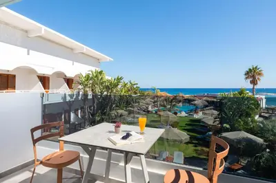 a table on a balcony with a view of the ocean at Aquarius Beach Hotel in Faliraki