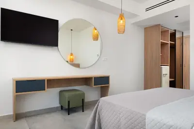 a bedroom with a bed and a mirror at Aquarius Beach Hotel in Faliraki
