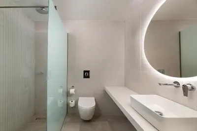 a bathroom with a sink and a toilet and a mirror at Aquarius Beach Hotel in Faliraki