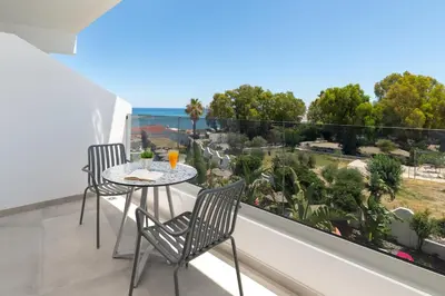a balcony with a table and chairs and a view of the ocean at Aquarius Beach Hotel in Faliraki