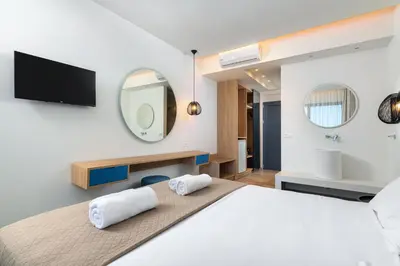 a bedroom with a large bed and a mirror at Aquarius Beach Hotel in Faliraki