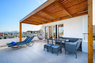 a patio with a wooden pergola and a table and chairs at Afantou Golf Luxury Villa in Afantou