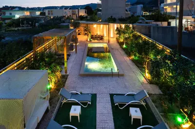a patio with chairs and a swimming pool at night at Afantou Golf Luxury Villa in Afantou