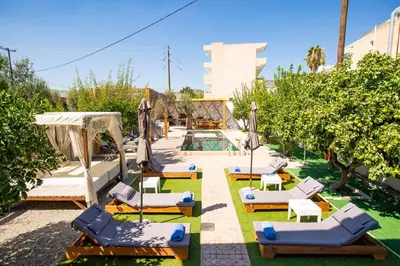 a group of lounge chairs and umbrellas next to a pool at Afantou Golf Luxury Villa in Afantou
