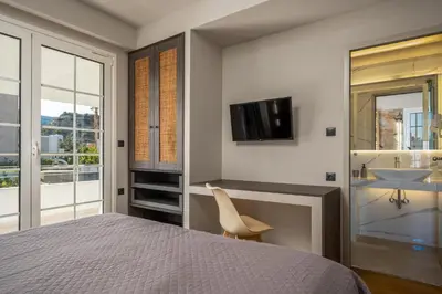 a bedroom with a bed and a sink and a television at Afantou Golf Luxury Villa in Afantou