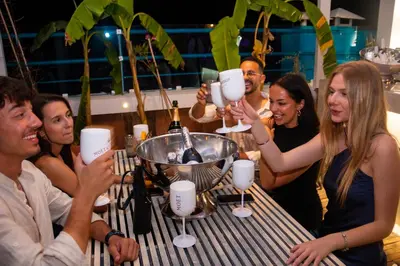 a group of people sitting at a table with wine glasses at Hotel Parthenon Rodos city in Rhodes Town
