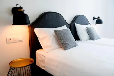 a bedroom with a bed with a black headboard and a table at Elements Villas in Lardos
