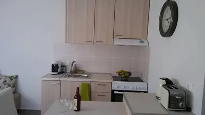 a kitchen with a sink and a clock on the wall at Nianthy Apartments in Faliraki