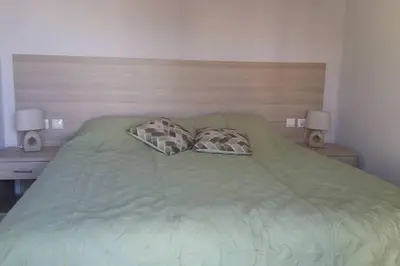 a bedroom with a green bed with two pillows at Nianthy Apartments in Faliraki