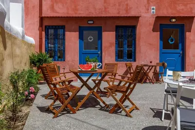 a wooden table and chairs in front of a building at Casita Del Sol Suites in Rhodes Town