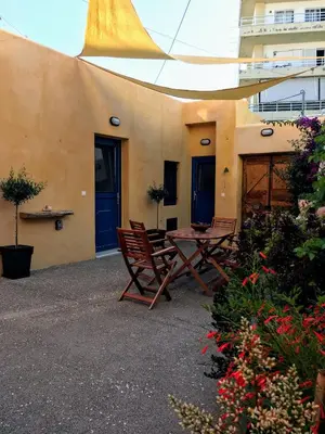 a patio with a table and chairs and a building at Casita Del Sol Suites in Rhodes Town