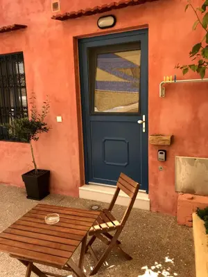 a wooden chair sitting in front of a door at Casita Del Sol Suites in Rhodes Town