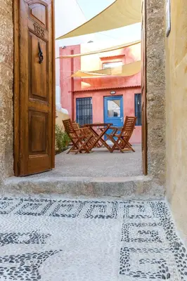 an open door to a patio with chairs and a table at Casita Del Sol Suites in Rhodes Town
