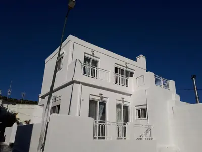 a white building with balconies on top of it at Seva's House in Psinthos