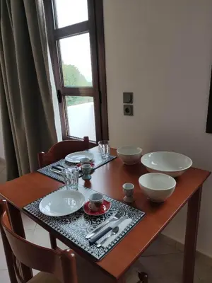 a wooden table with plates and bowls on it at Tilos Fantasy in Livadia