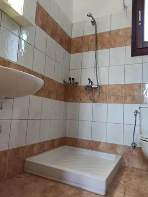 a bathroom with a shower and a tub and a sink at Tilos Fantasy in Livadia