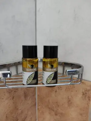 two bottles of honey on a rack in a bathroom at Tilos Fantasy in Livadia