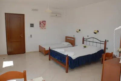 a bedroom with two beds and a door in it at Tilos Fantasy in Livadia