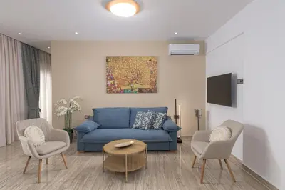 a living room with a blue couch and two chairs at Sea and the city in Rhodes Town