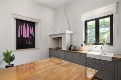 a kitchen with a wooden table and a sink at Villa Eleonora in Rhodes Town