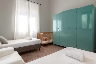 a bedroom with two beds and a blue cabinet at Villa Eleonora in Rhodes Town
