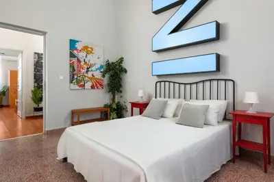 a bedroom with a white bed and two red tables at Villa Eleonora in Rhodes Town