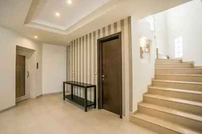 a hallway with stairs and a wooden door at Aegean Blue Villa in Koskinou