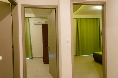 a hallway with green walls and a door to a room at Maestro Apartments Faliraki in Faliraki