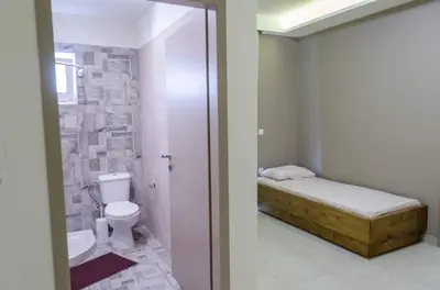 a small bathroom with a bed and a toilet at Maestro Apartments Faliraki in Faliraki