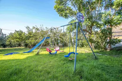 a group of swings in a yard at Irinna Hotel-Apartments in Faliraki