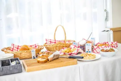 a table topped with bread and baskets of food at Irinna Hotel-Apartments in Faliraki
