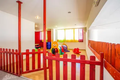 a childs room with a red fence in a room at Irinna Hotel-Apartments in Faliraki