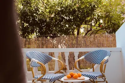 two chairs and a plate of oranges on a table at Afroditi Junior Suites in Archangelos