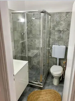 a bathroom with a shower with a toilet and a sink at Afroditi Junior Suites in Archangelos