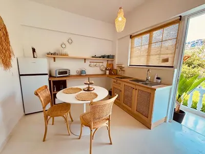 a kitchen with a table and chairs and a sink at Afroditi Junior Suites in Archangelos