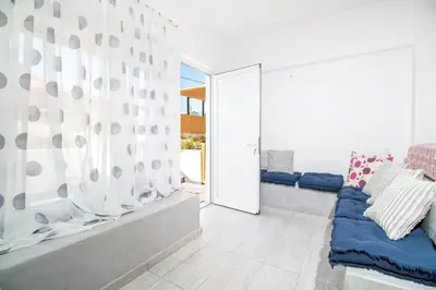 a living room with a couch and a sliding glass door at Len Art Alternative Studios in Faliraki