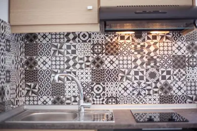 a kitchen with a sink and a tile wall at Len Art Alternative Studios in Faliraki